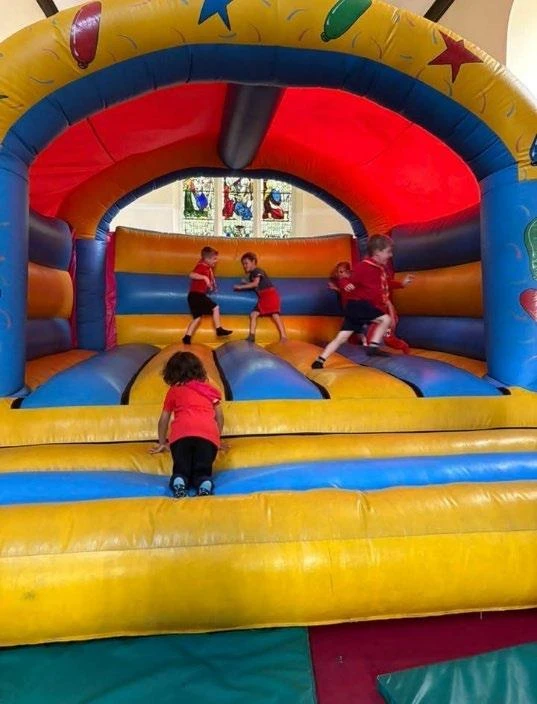 The hall set up for a family celebration with a bouncy castle